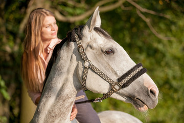 Woman riding a horse during sunset in countryside