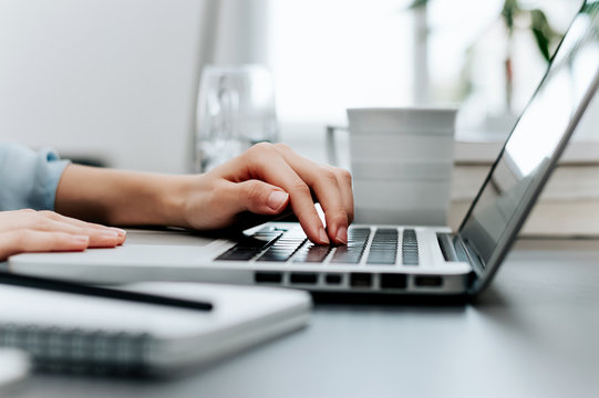 Side View And Close Up Of Woman's Hands Typing On Laptop Keyboard.