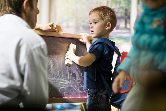 Boy cleaning blackboard with duster