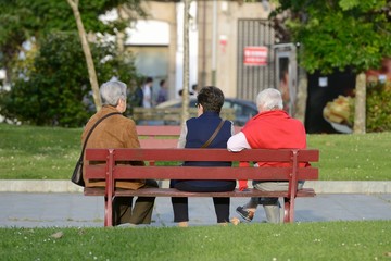 three elderly women on a street bench