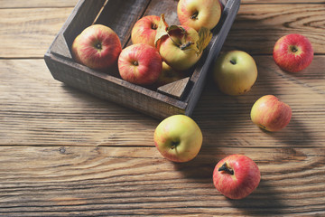 Ripe apples in box  on wooden background