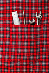 Repair hand tools in checkered shirt pocket