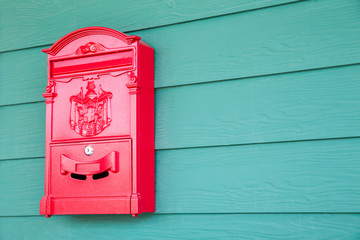 Red mailbox on classic green woonden background