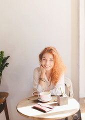 Beautiful smiling young woman with cup of coffee.