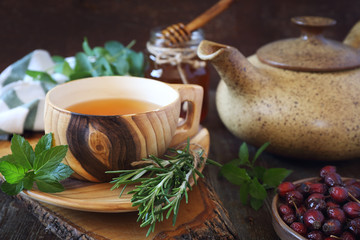 Fototapety  Zdrowa herbata ziołowa z ziołami leczniczymi, owocami róży i miodem