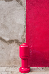 Beautiful colorful house facade on Burano island, north Italy. Old damaged half grey half red...