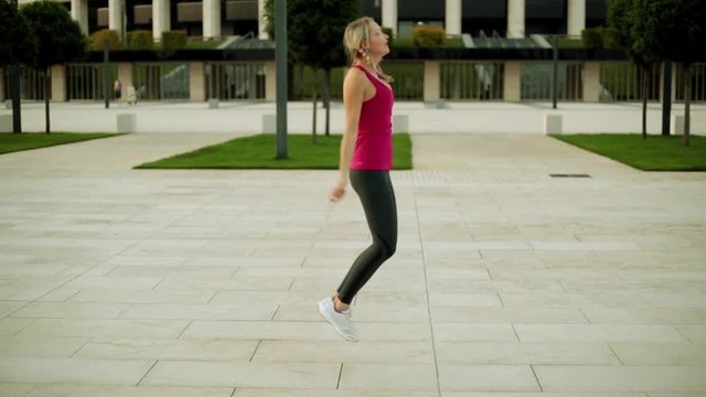 Young woman jumping rope in the park. The girl is engaged in fitness.
