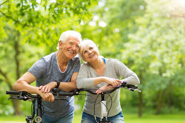 Senior Couple Riding Bikes In Park

