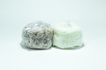 Fototapeta na wymiar Brown rice and jasmine rice in a plastic bag on white background.