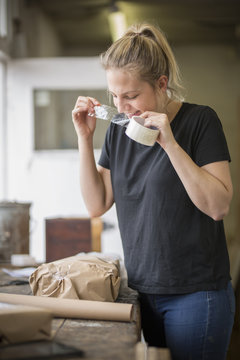 woman using sticky tape  biting off a bit with her teeth. 