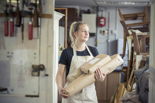 Woman carrying parcels ready for posting from her workshop