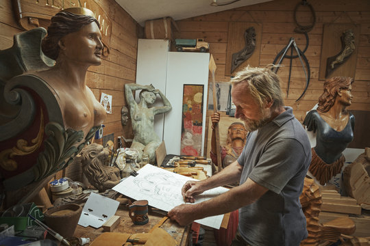 A marine wood carver and designer at work in his workshop