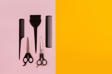 Combs and hairdresser tools on color background top view