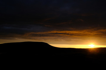 Sunset and a cloudy sky over Pendle Hill, Lancashire