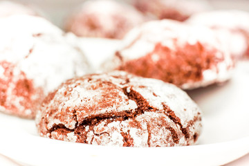 Round cookies stack on a white plate, powder sugar
