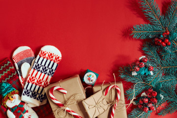 Fototapeta premium Świąteczna kompozycja szyszek, gałęzi świerkowych i stosu pudełek na czerwonym tle