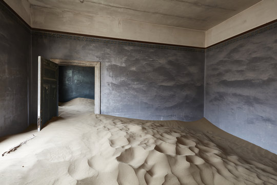 Interior of an abandoned building full of sand.