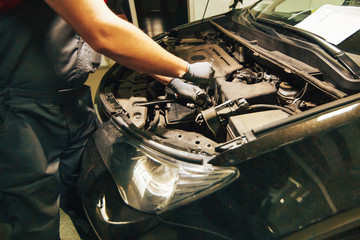 Fototapeta na wymiar Car engine repair. An auto mechanic fixing an engine