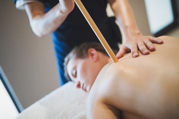 Masseur massaging masseuse at wellness resort