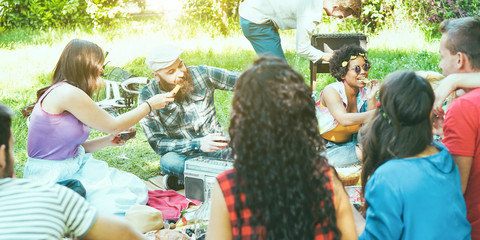 Group of friends making picnic barbecue outdoor in city park