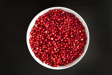 cranberries in bowl on black background