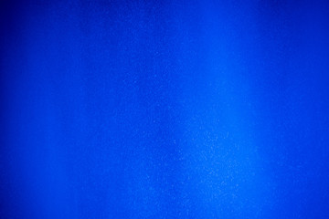 background blue with a splash of water illuminated by artificial lighting