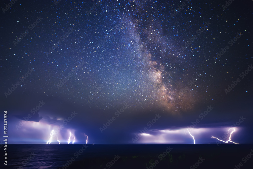 Wall mural thunderstorm on sea and milky way night sky