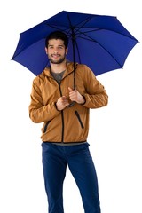 Smiling man standing under umbrella against white background