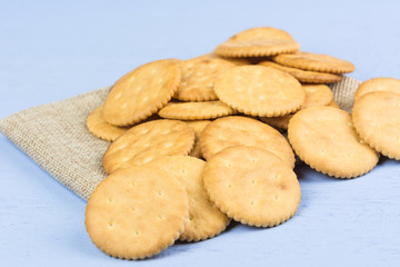 pile of cracker on calico fabric with light blue wooden background, close up