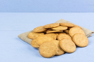 pile of cracker on calico fabric with light blue wooden background