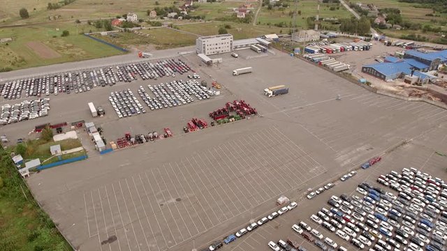 Aerial top down bird view of new car storage parking lot showing imported new vehicles or ready to export new automobiles storage facility car industry for American and European market for car sales