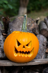 Halloween themes. Autumn halloween jack-o-lantern on autumn wooden background