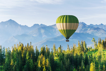 Obraz premium Fantastic snow-capped mountains in the beautiful cumulus clouds. A balloon in the background. Carpathians. Ukraine