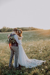 Beautiful bride and groom at sunset in green nature.