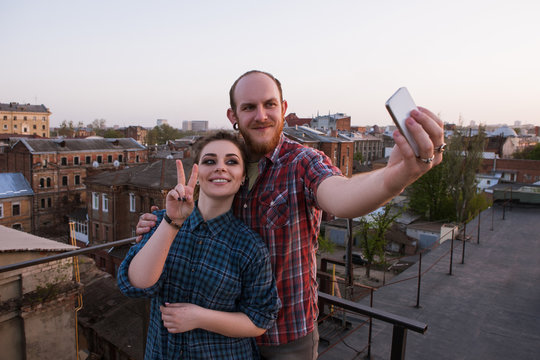 Romantic couple selfie. Modern technology. Young happy people taking picture on roof, joyful leisure time, stylish youth outdoors, fun concept