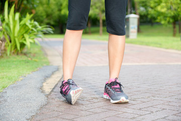 Sporty woman ankle sprain while jogging or running at park. - obrazy, fototapety, plakaty
