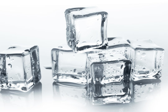 Transparent ice cubes with water drops on white