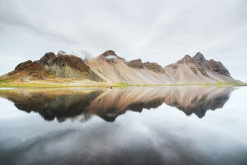 Amazing mountains reflected in the water at sunset. Stoksnes, Iceland - obrazy, fototapety, plakaty