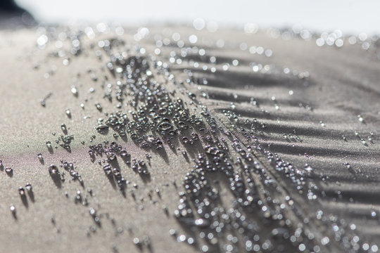 Hydrophobic rain water droplets forming beads on a waterproof parasol umbrella surface.