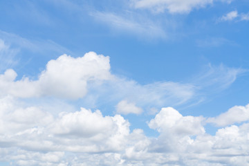 The soft white clouds float in the bright blue sky