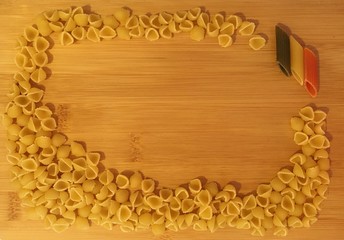 Dry pasta on wood background. Italian flag pasta Penne.