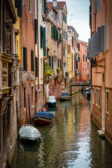 Fototapeta na wymiar Old narrow street with a boats in Venice, Italy