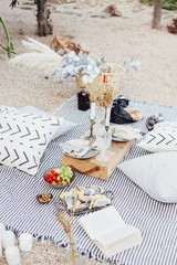 Fotobehang Eetkamer Top view on still life outdoor picnic blanket setup for romantic day or night out for hipster stylish couple, wedding, proposal happening with candles and chic snacks  © BublikHaus
