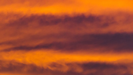 Background texture of dramatic sunset sky with orange clouds after thunderstorm