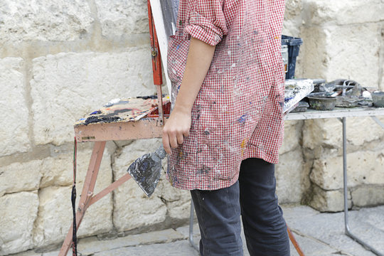 Woman artist painting in the street