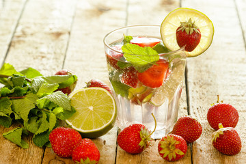 Fototapeta na wymiar Refreshing drink with strawberry, lime and mint