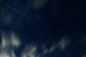 Fototapeta na wymiar Night sky with stars and clouds in motion