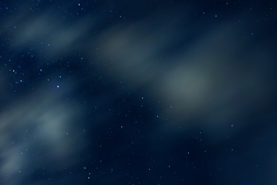 Night sky with stars and clouds in motion