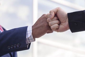 Close-up of two businessmen giving fist bump