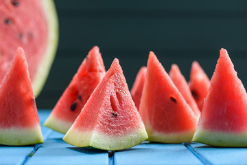 Many bright juicy watermelon slices cut into triangular shape. Summer refreshing snack